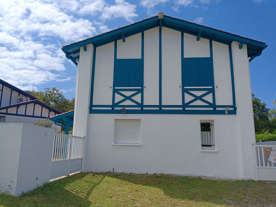 Maison blanche et bleue avec volets bleus