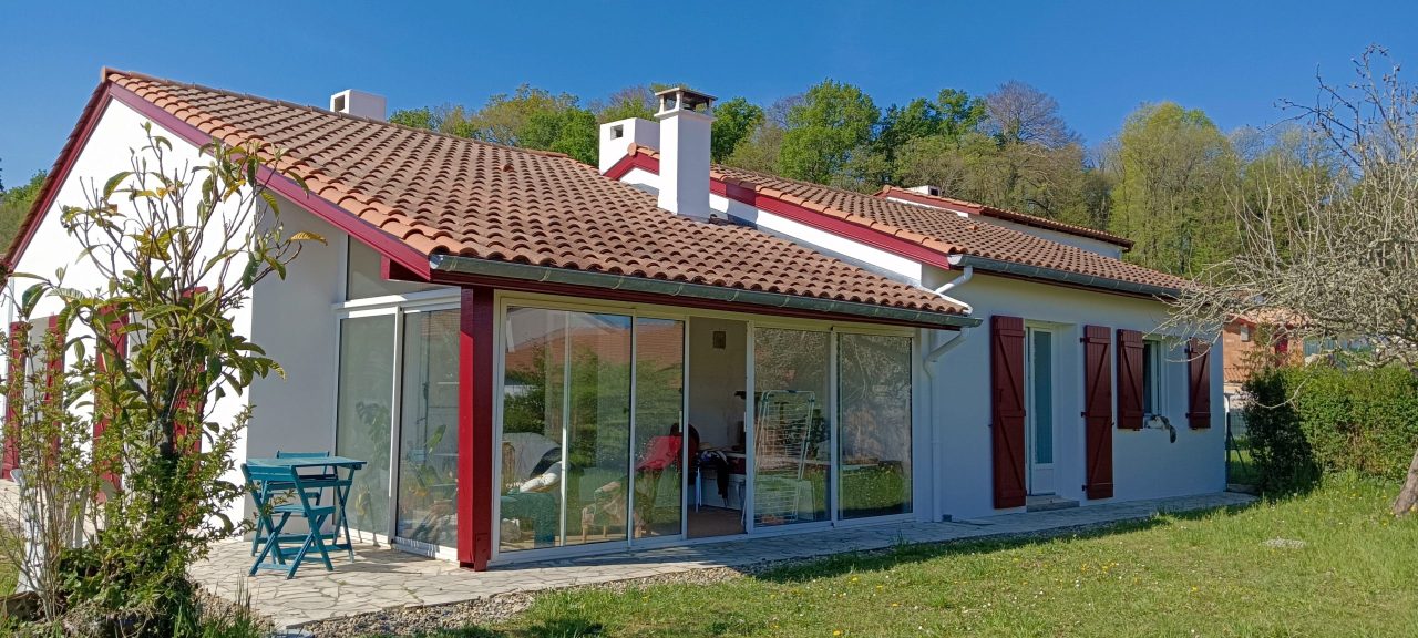 Maison moderne avec toit rouge et fenêtres en verre