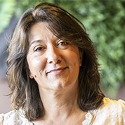 Femme souriante aux cheveux bruns mi-longs.