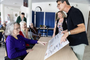 Homme montrant un plan à un groupe de personnes.
