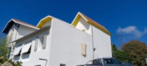 Bâtiment blanc avec toit rouge et fenêtres fermées