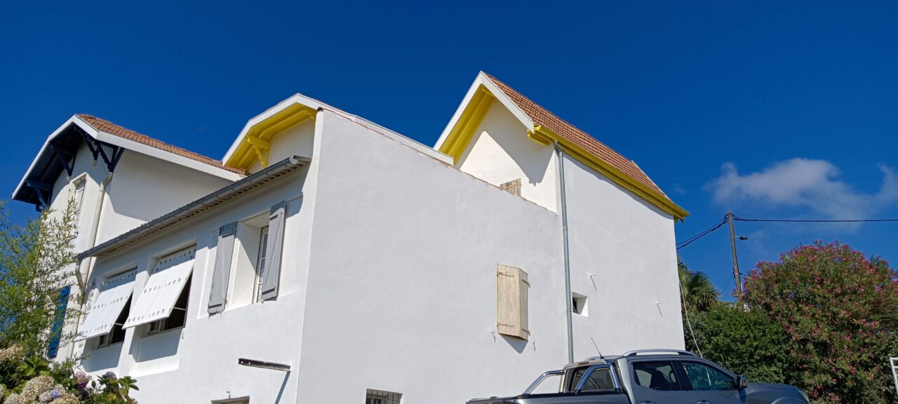 Bâtiment blanc avec toit rouge et fenêtres fermées