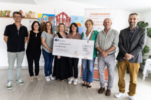 Groupe de personnes tenant un chèque, remise de don, événement communautaire.